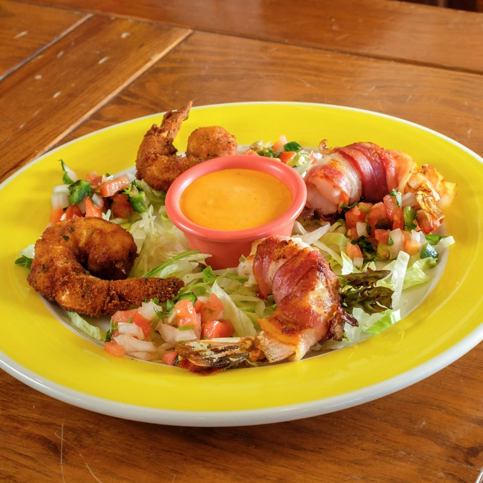 Plaza Garibaldi Mezcaleria's fried and bacon-wrapped shrimp with pico de gallo, lettuce, and dipping sauce.