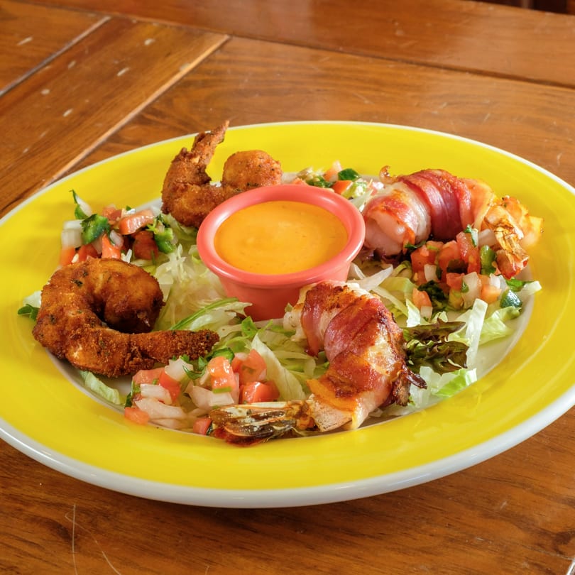 Plaza Garibaldi Mezcaleria's fried and bacon-wrapped shrimp with pico de gallo, lettuce, and dipping sauce.